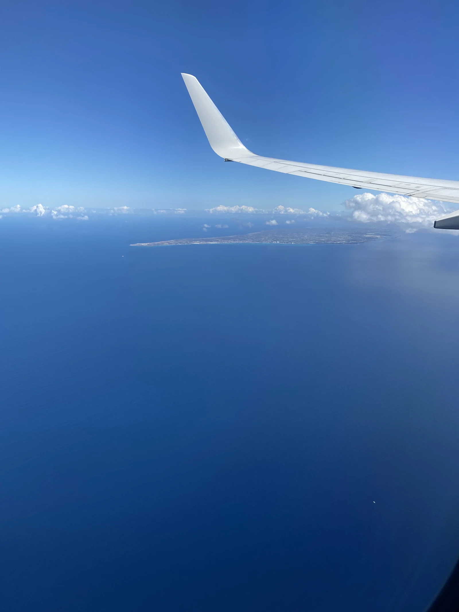 Aircraft wing over turquoise Aegean waters