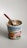 Ben & Jerry's ice cream tub labeled 'Netflix & Chilll'd Non-Dairy' is topped with light-colored ice cream. A wooden spoon is sticking out of the ice cream, suggesting it's ready to be eaten. The label shows a pretzel and a swirl of peanut butter, hinting at the flavors.