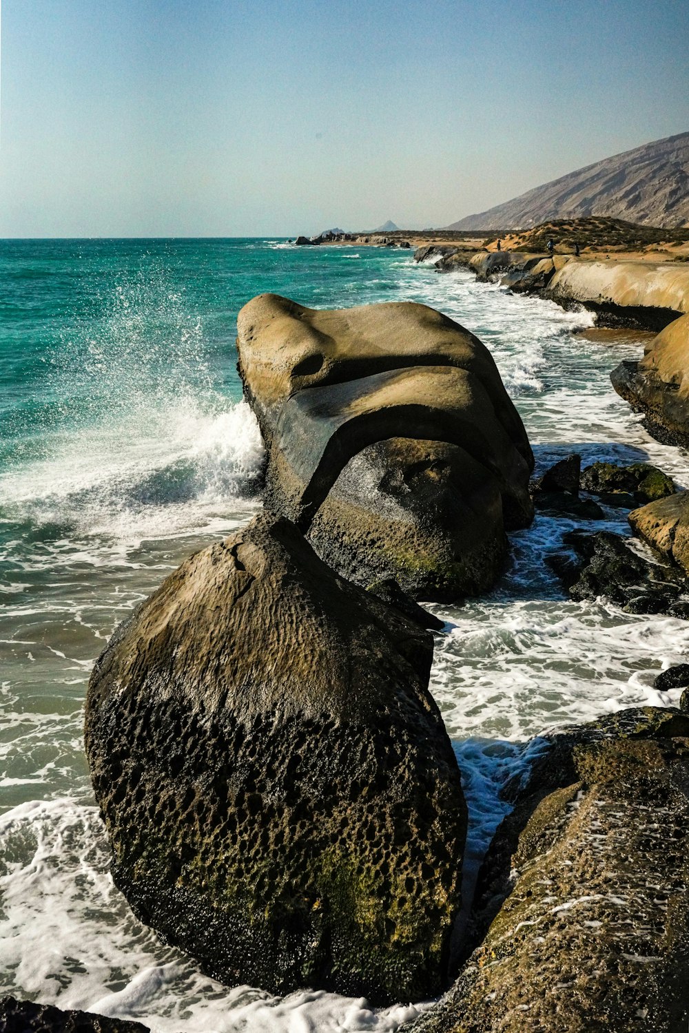 Ein großer Felsen auf einem Strand neben dem Meer