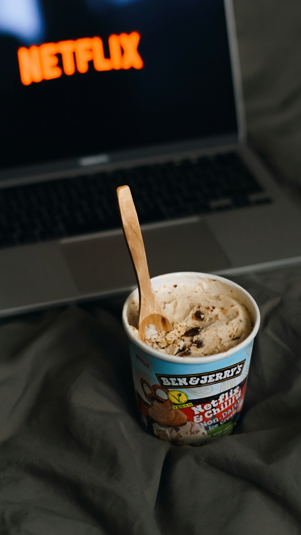Una taza de helado sentado frente a una computadora portátil