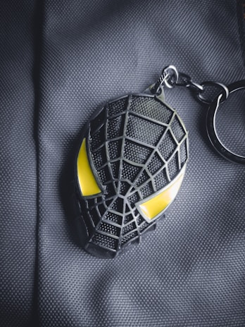 Close-up of a modern orange and black keychain with the Portal das Chaves logo