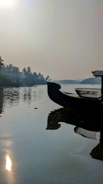 a boat is sitting on the water near the shore