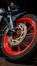 a close up of a motorcycle wheel with red spokes