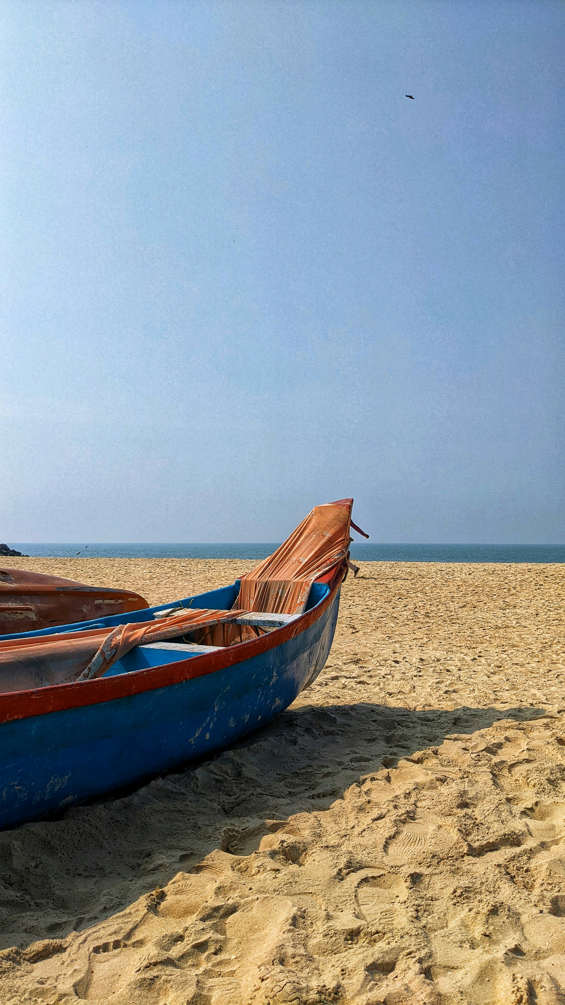 Ein blaues Boot, das auf einem Sandstrand sitzt