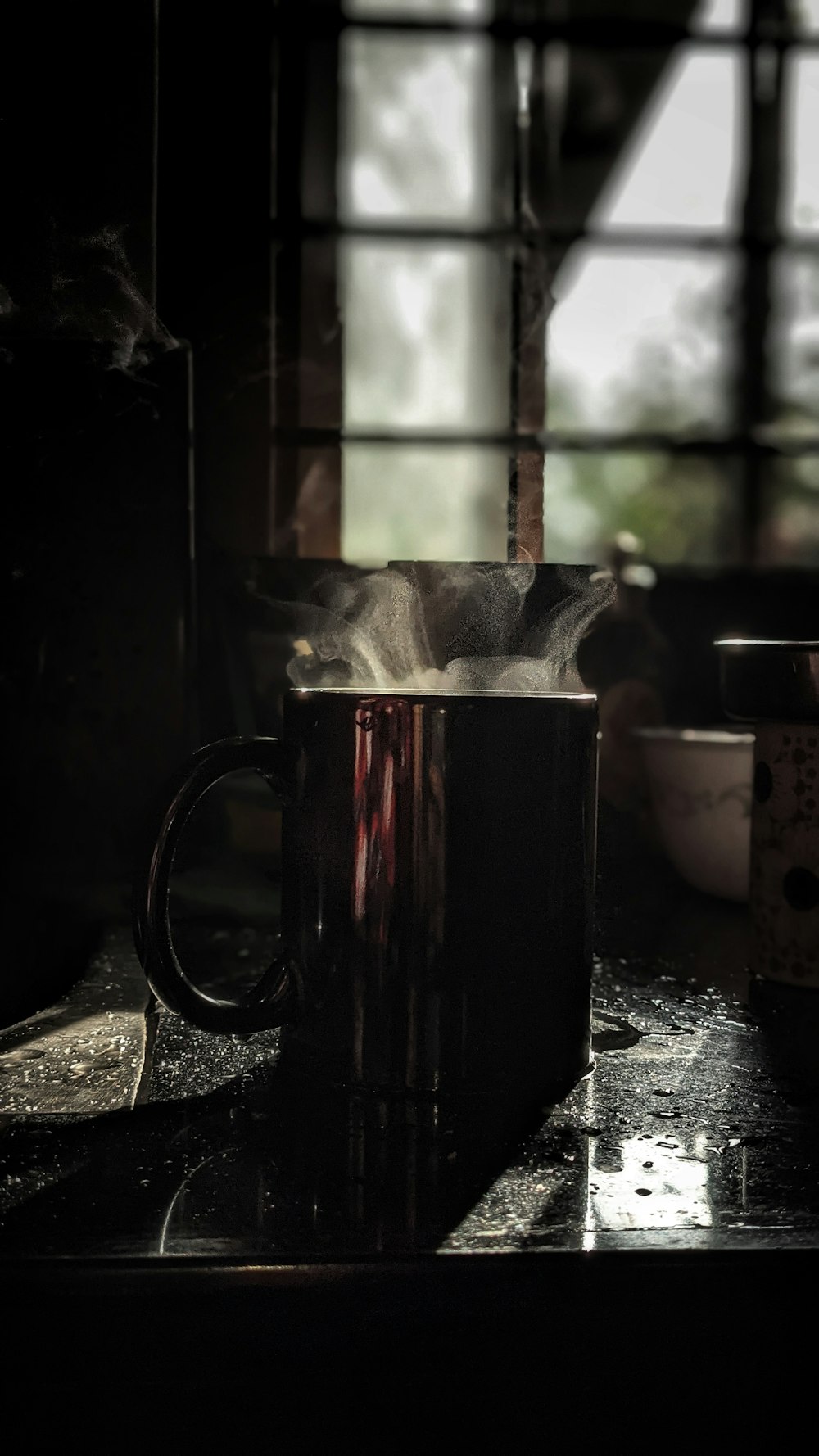 a coffee mug sitting on top of a table next to a window