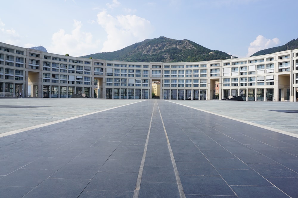 a large building with mountains in the background