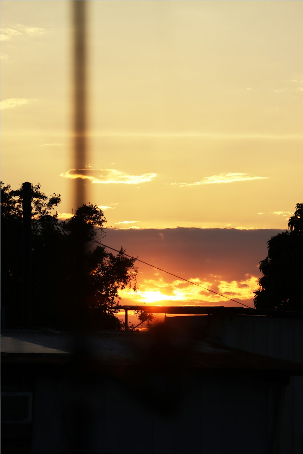 the sun is setting behind a building and trees