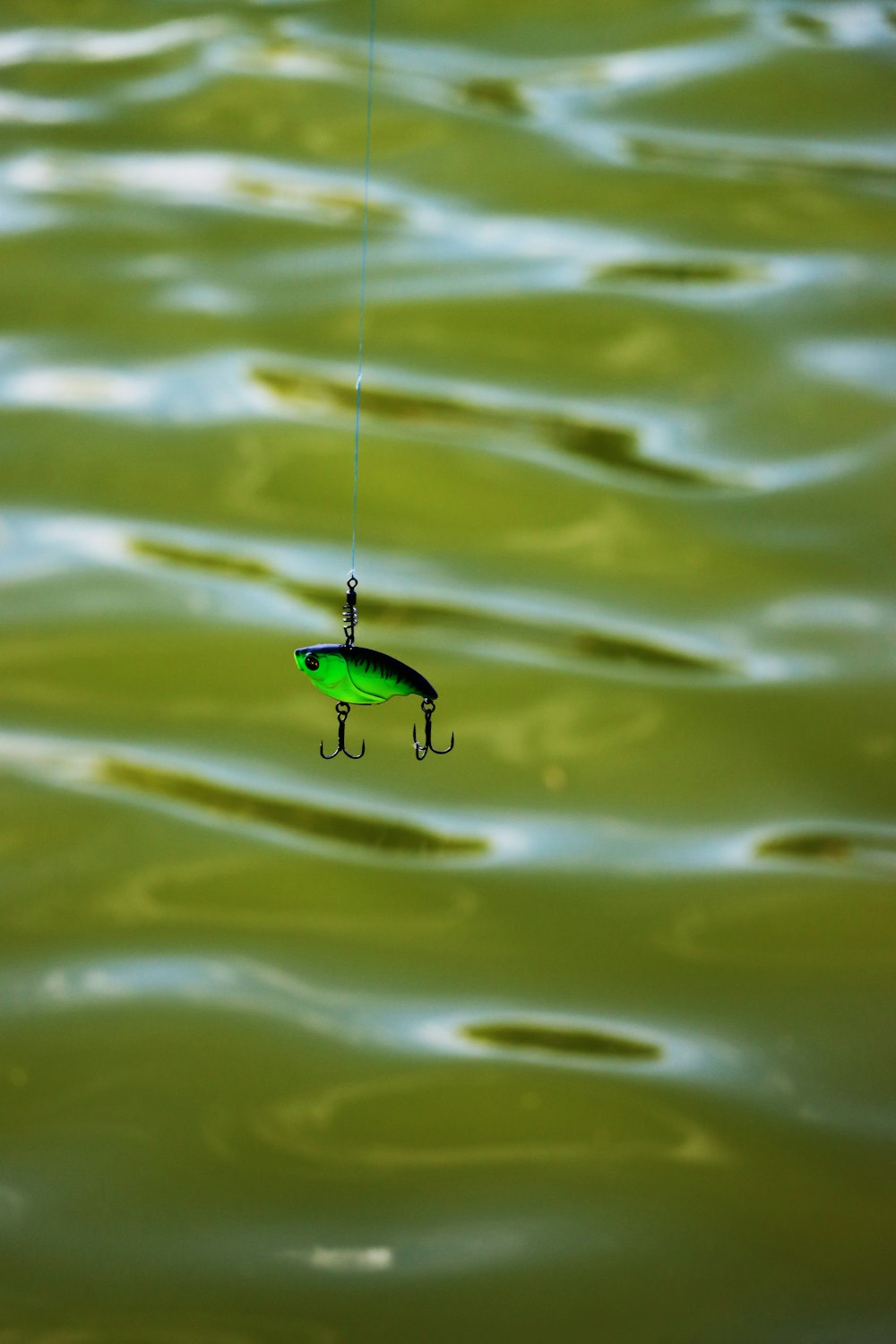 a green fishing lure hanging from a hook
