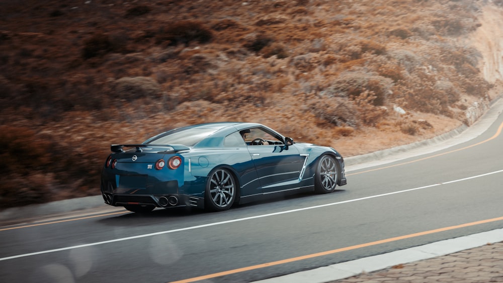 a blue sports car driving down the road
