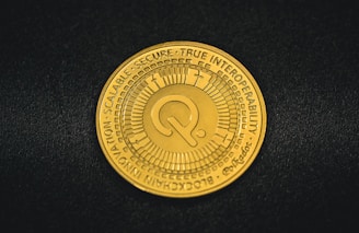 a close up of a gold coin on a black surface