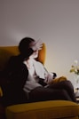 a woman sitting on a yellow chair in a room