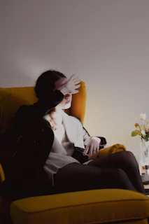 a woman sitting on a yellow chair in a room