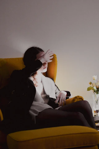 a woman sitting on a yellow chair in a room