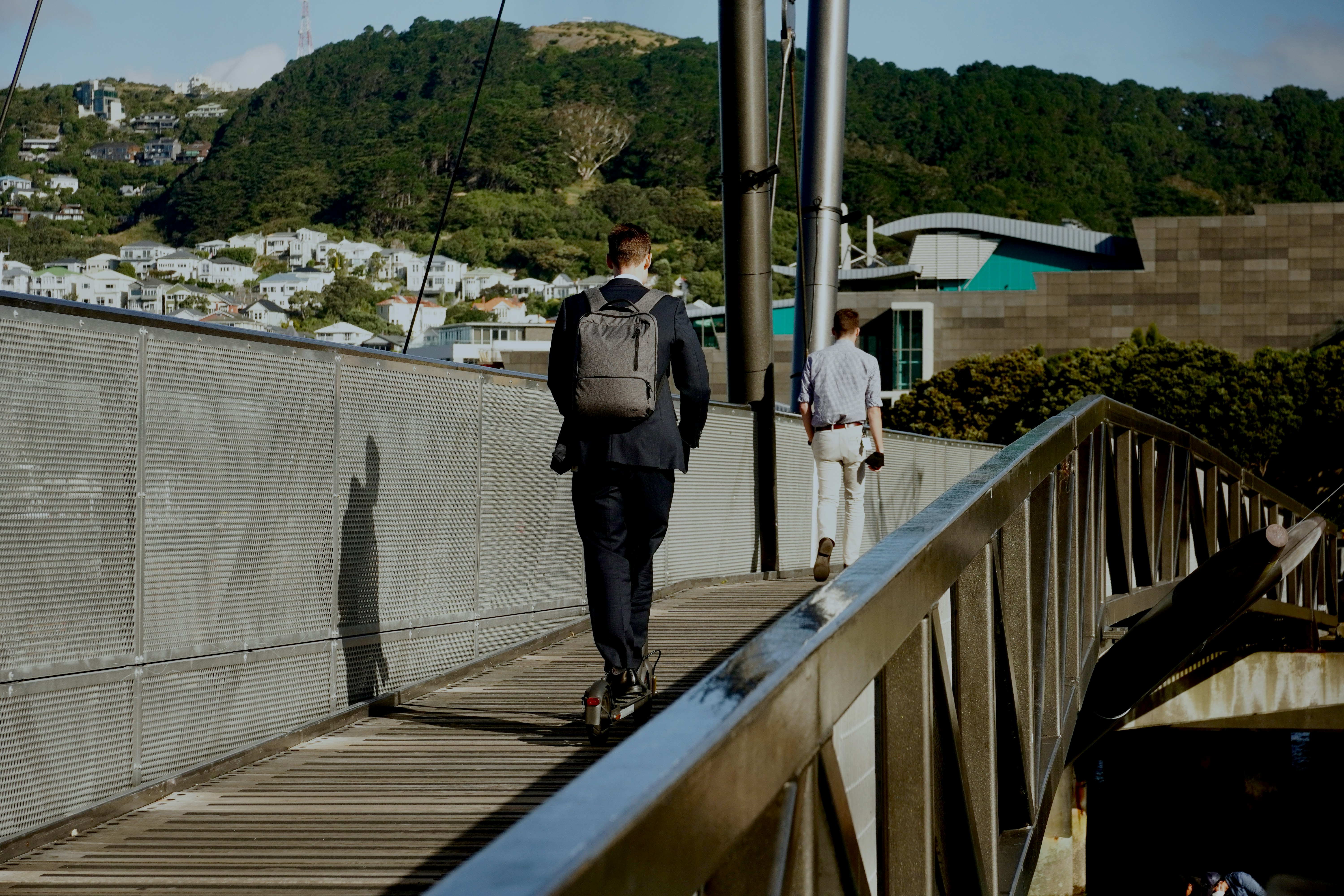 a man with a backpack walks across a bridge