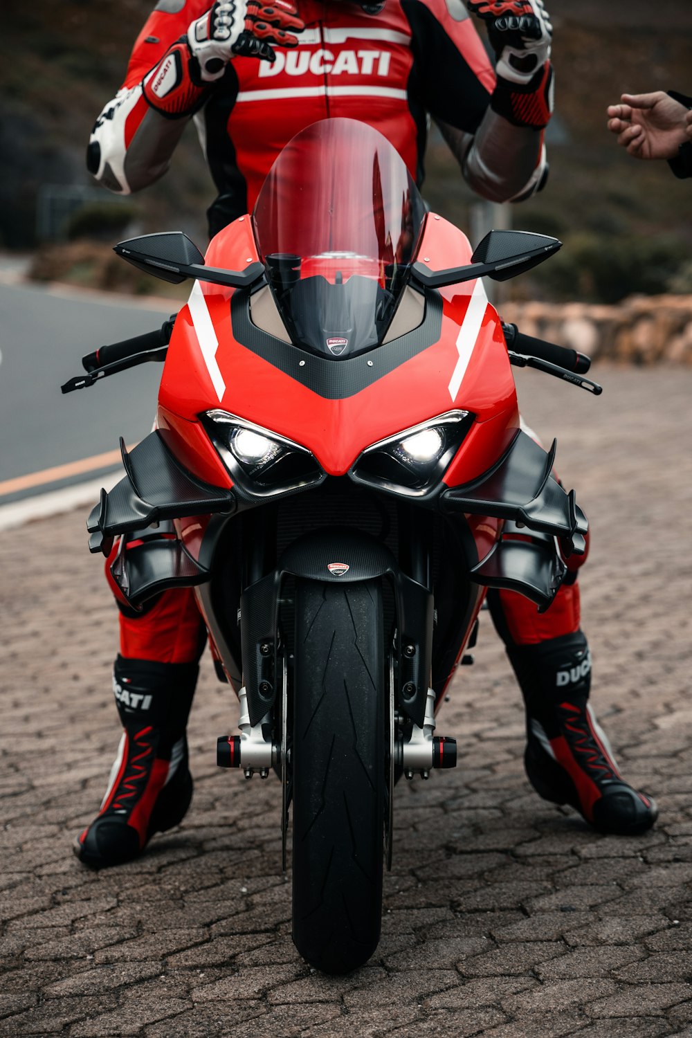 a man riding on the back of a red motorcycle