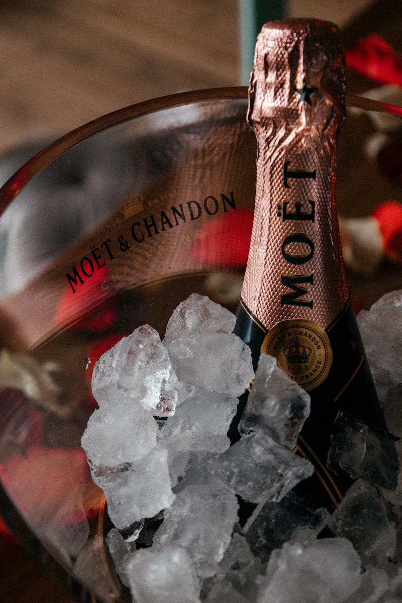 Botella de champán rosado enfriándose en una cubitera con hielo