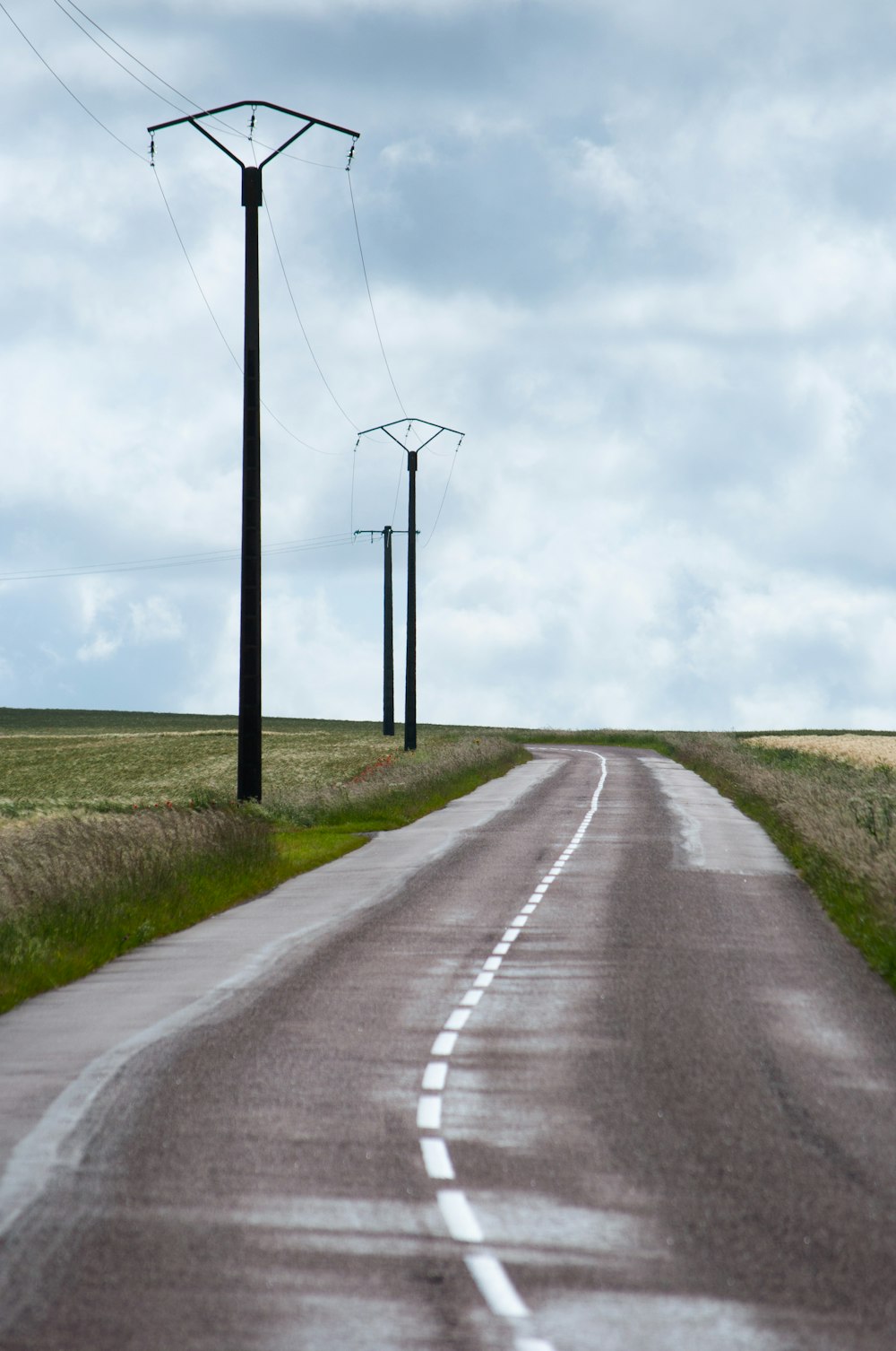 an empty road with power lines and telephone poles
