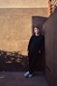 a man leaning against a wall with his hands on his hips