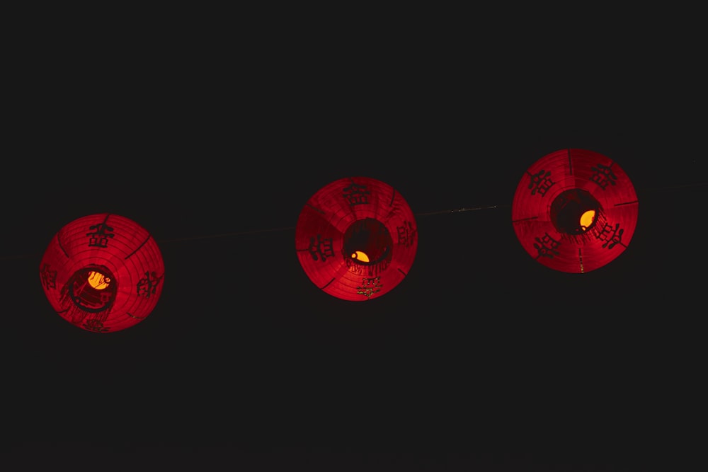 three red paper lanterns hanging from a string