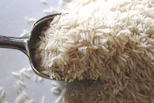 a spoon filled with rice on top of a table