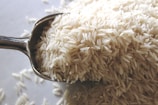 a spoon filled with rice on top of a table