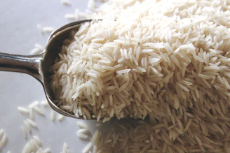 a spoon filled with rice on top of a table