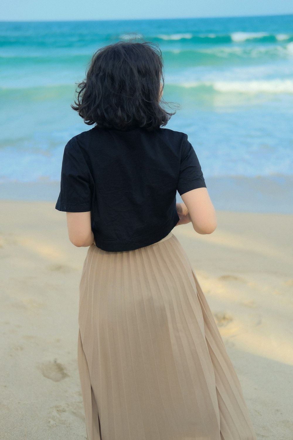 a woman standing on top of a sandy beach