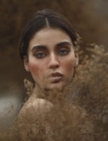 A captivating model with striking features in a natural landscape.