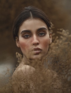 A captivating model with striking features in a natural landscape.