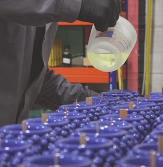 a man pouring a container of liquid into a container