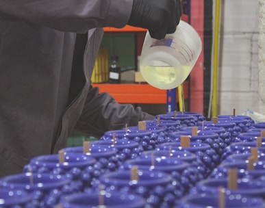 a man pouring a container of liquid into a container