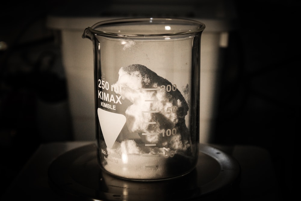 a glass filled with liquid sitting on top of a table