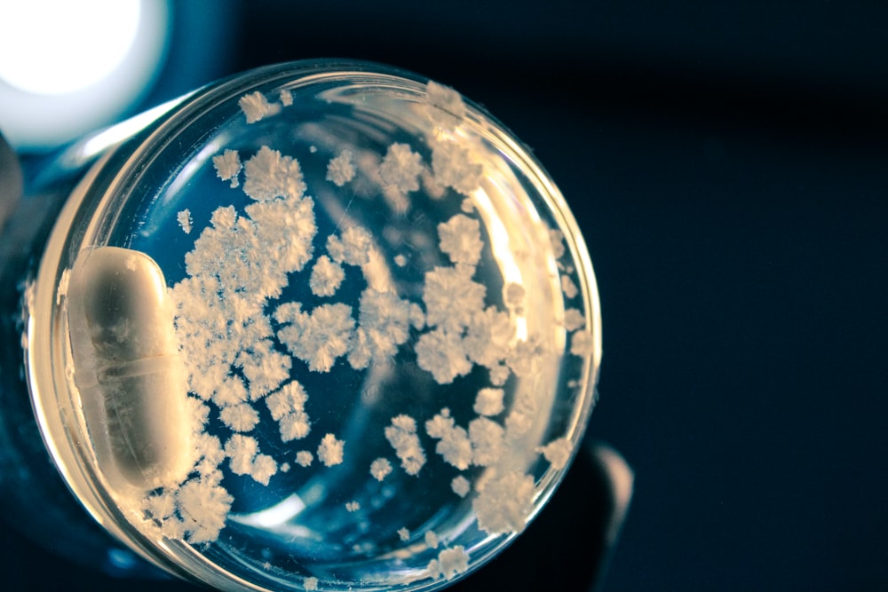 a close up of a person holding a glass with a substance inside of it