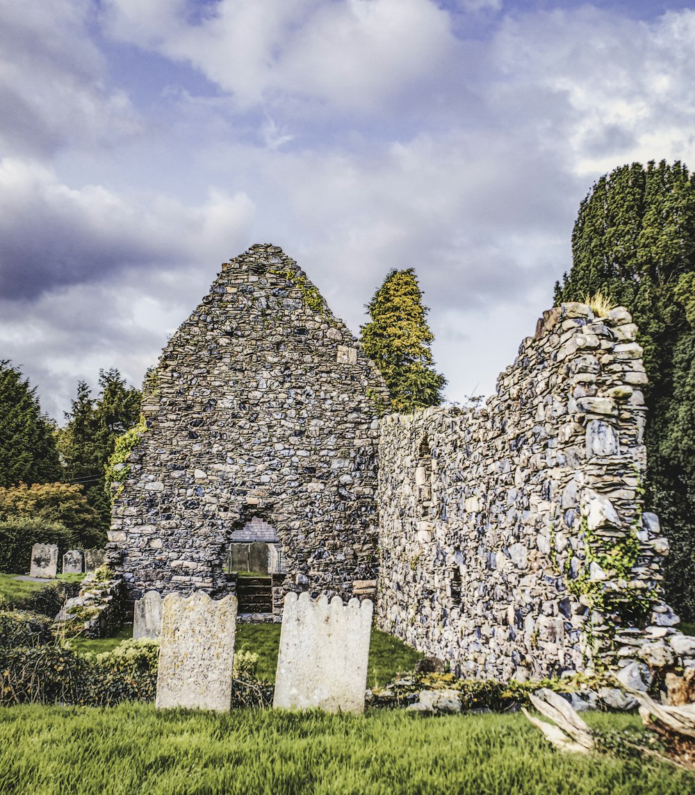 a stone building with a cemetery in the background