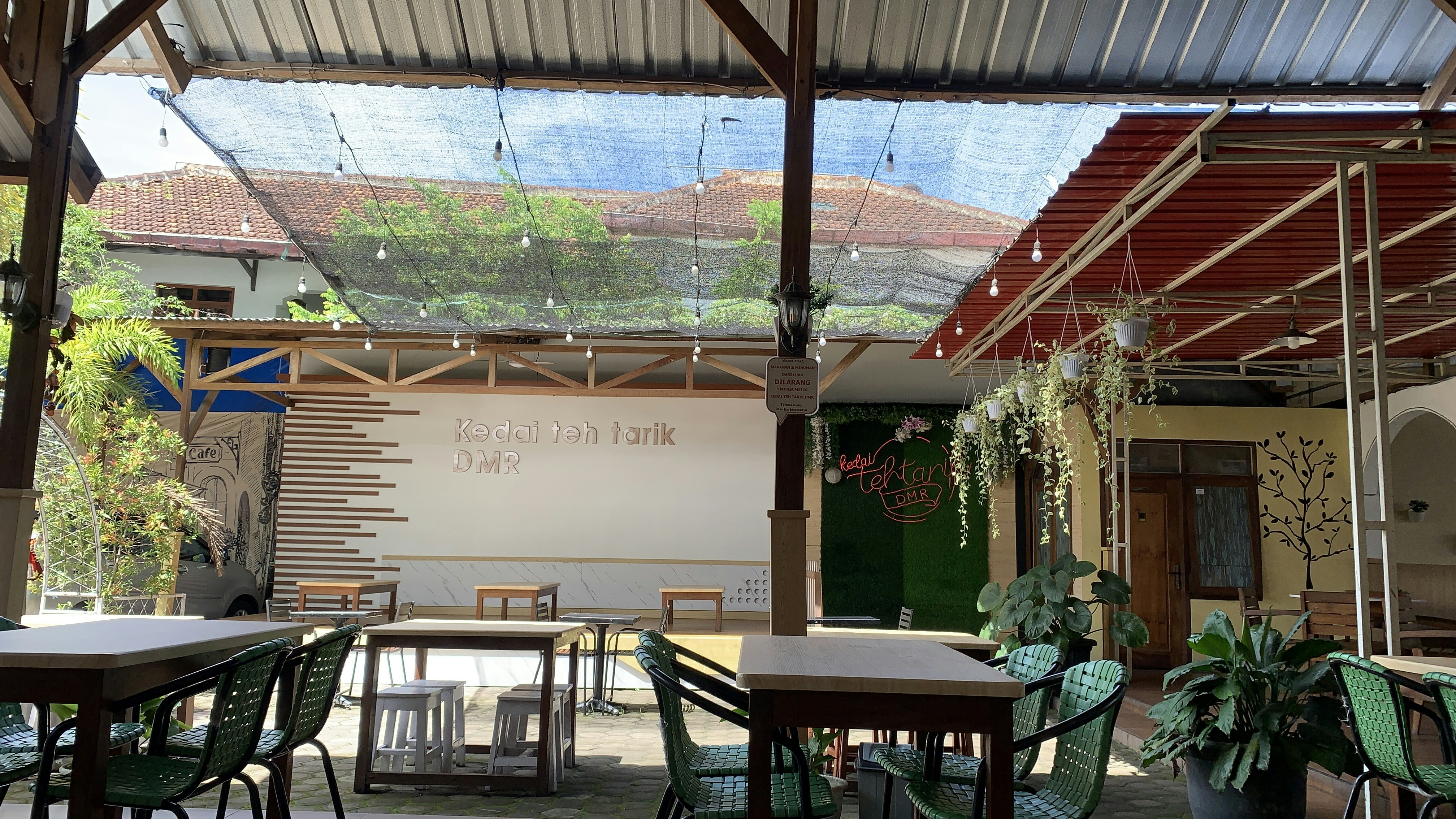 restoran dengan meja dan kursi di bawah atap