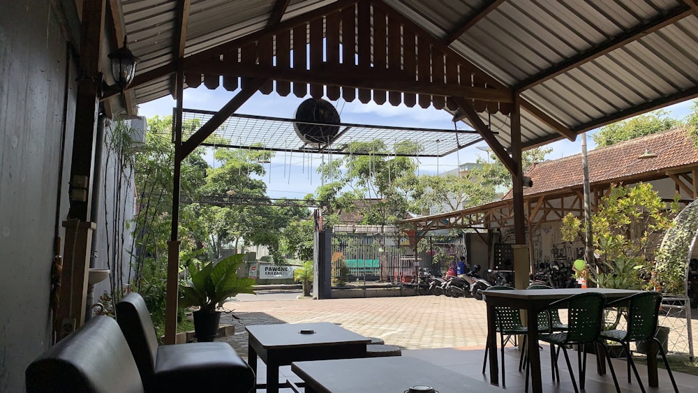 a restaurant with tables and chairs under a roof