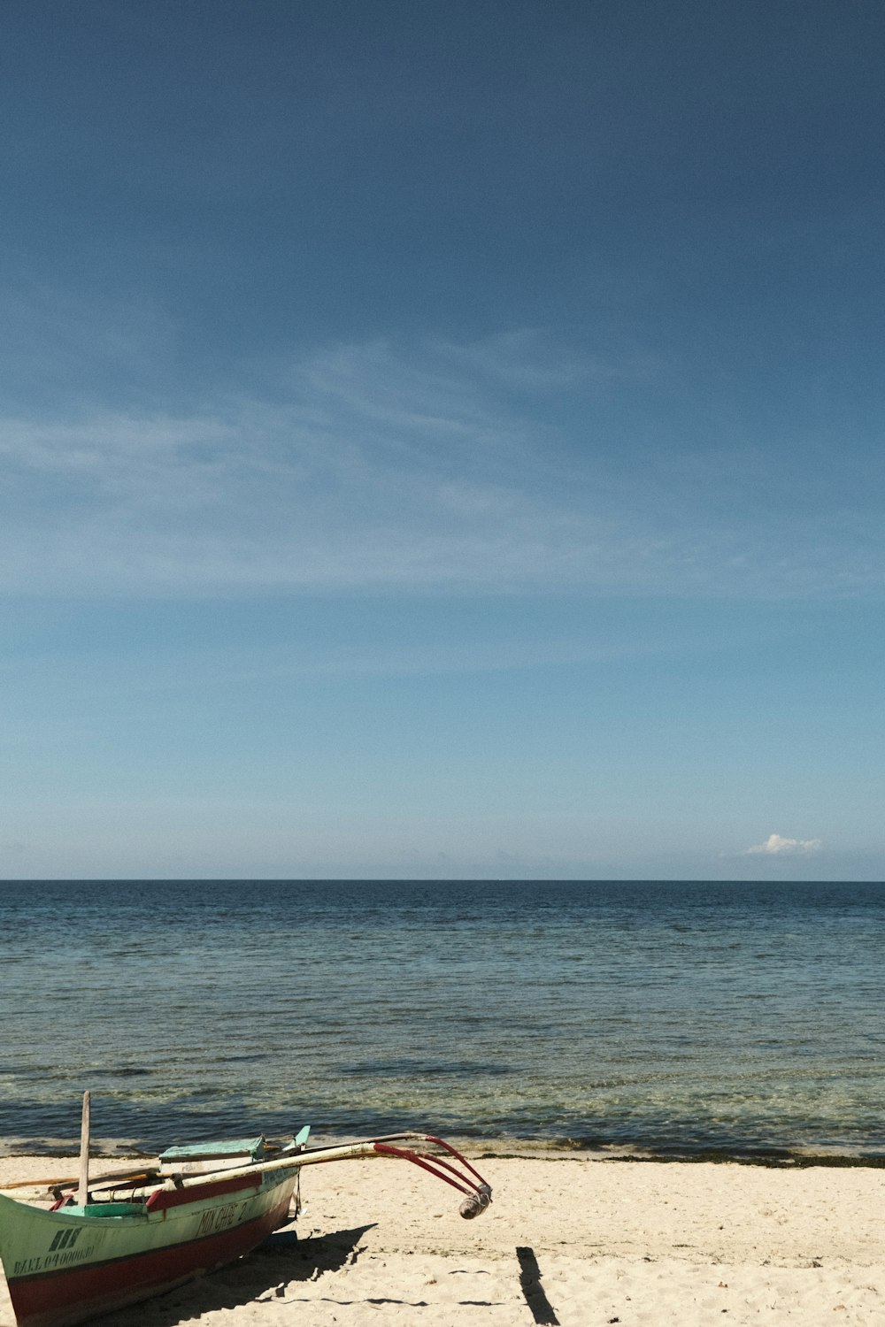 a boat sitting on top of a sandy beach