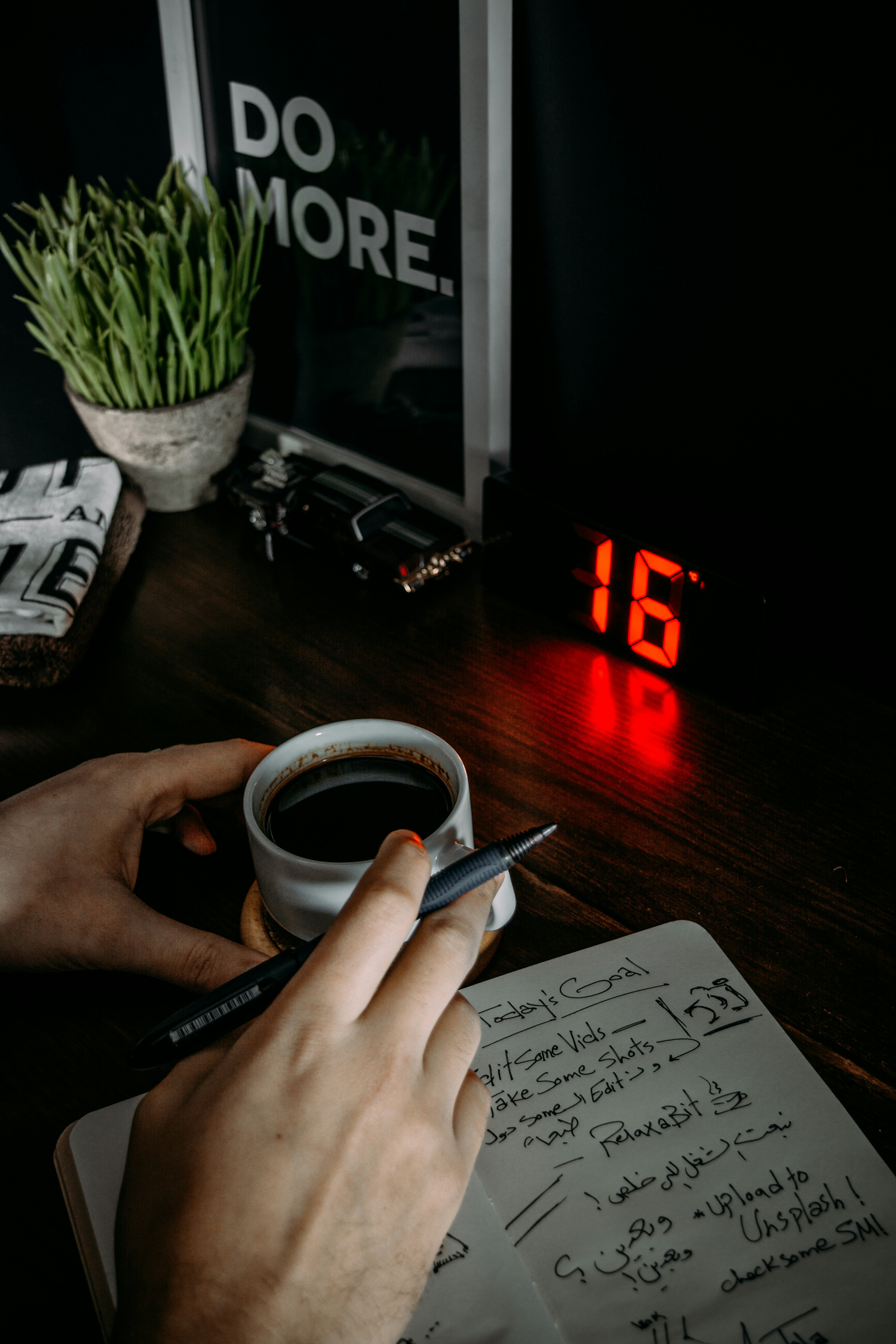 Person schreibt neben einer Kaffeetasse in ein Notizbuch – einen Rauchstopp konkret vorbereiten
