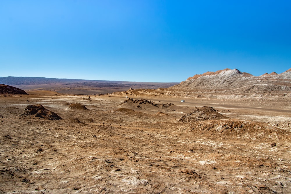 a dirt field with a mountain in the background