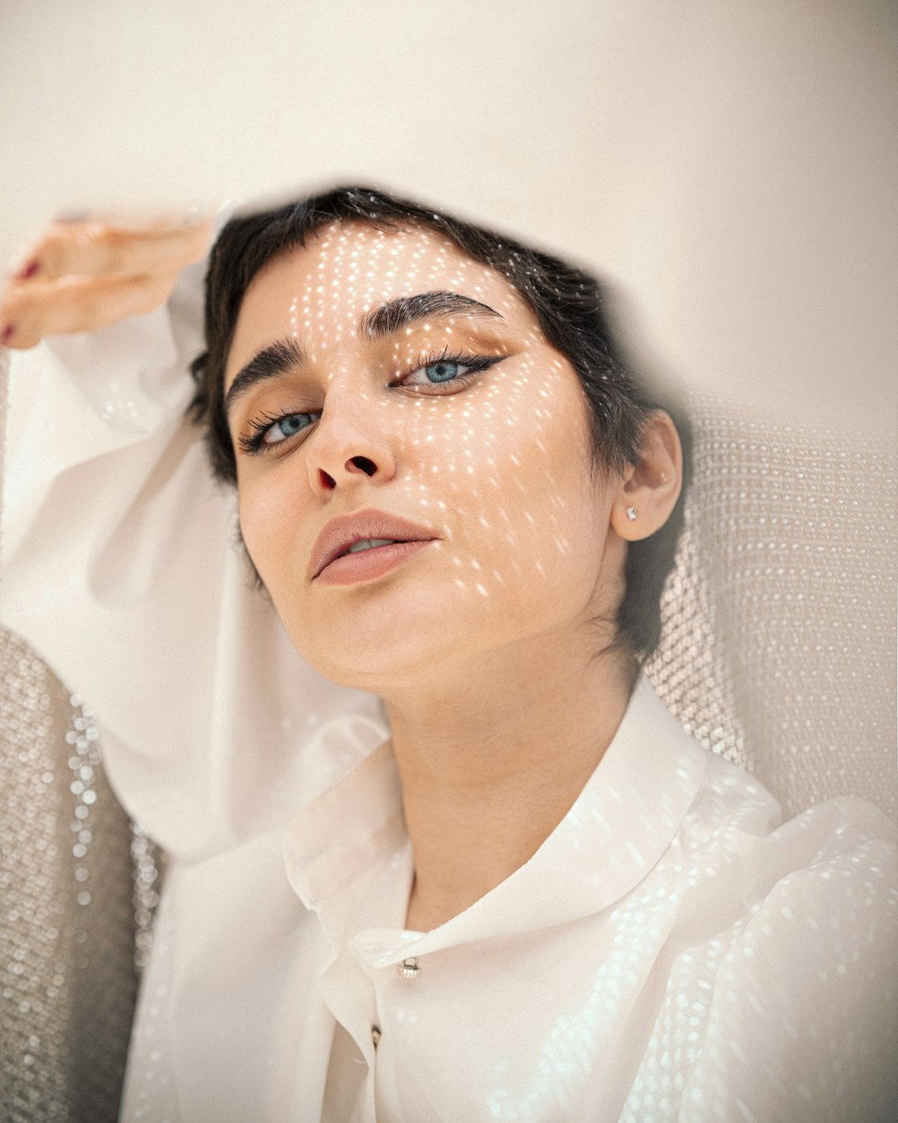 a woman in a white shirt is holding her head