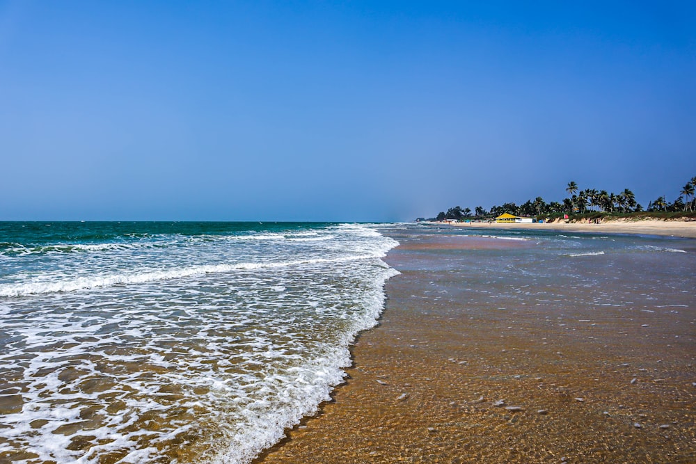 a sandy beach with waves coming in to shore