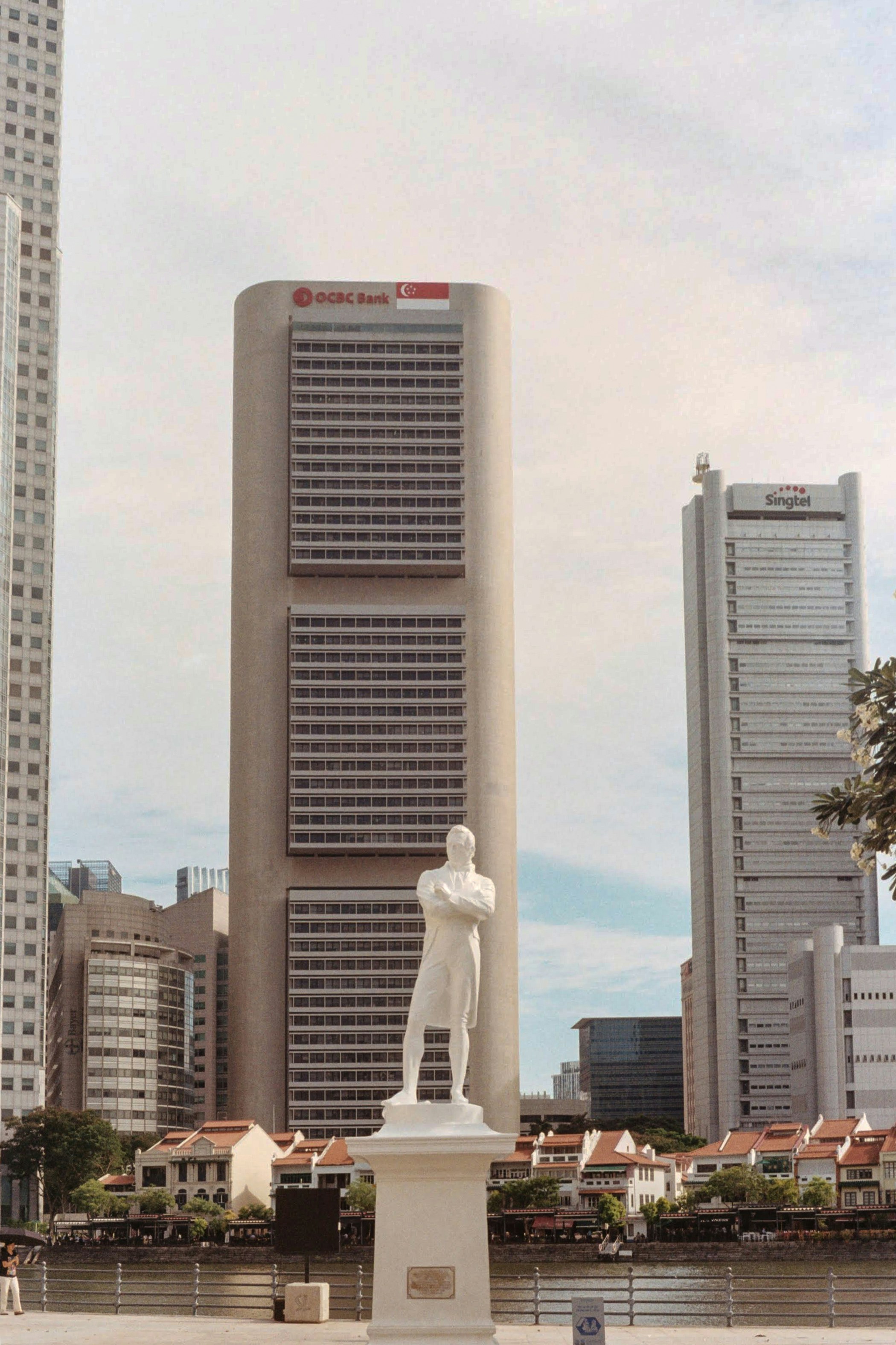a statue of a man standing in front of a tall building