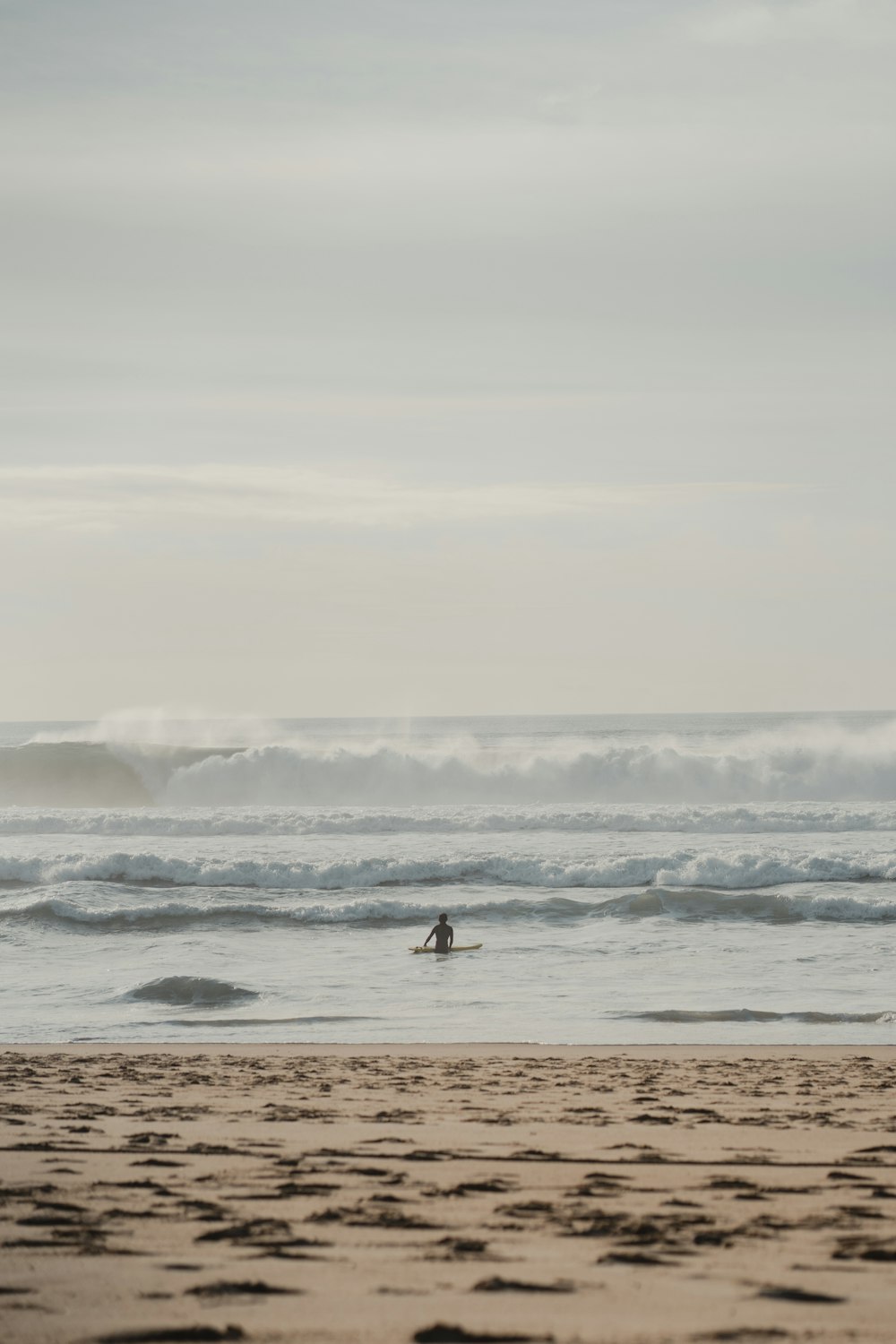 Eine Person, die auf einem Surfbrett auf einem Sandstrand fährt
