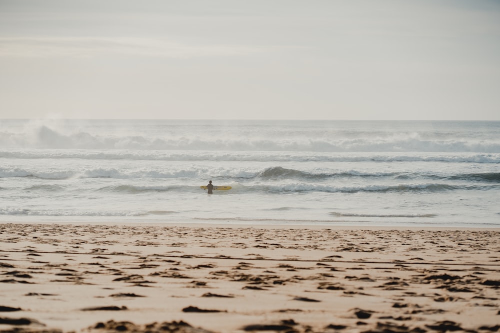 a person on a surfboard in the water at the beach