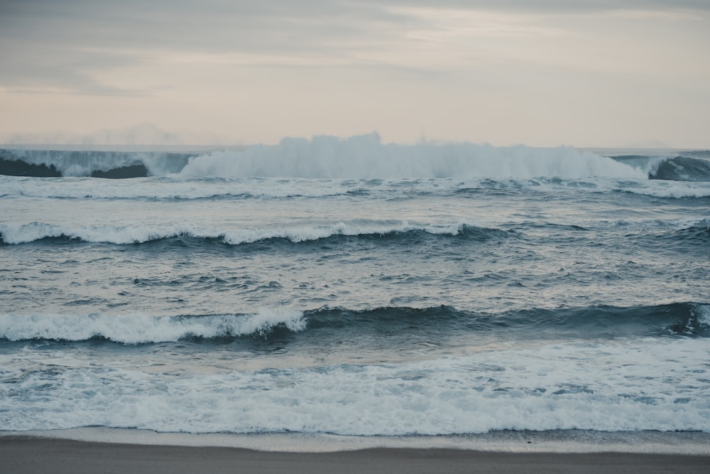 the ocean waves are crashing on the beach