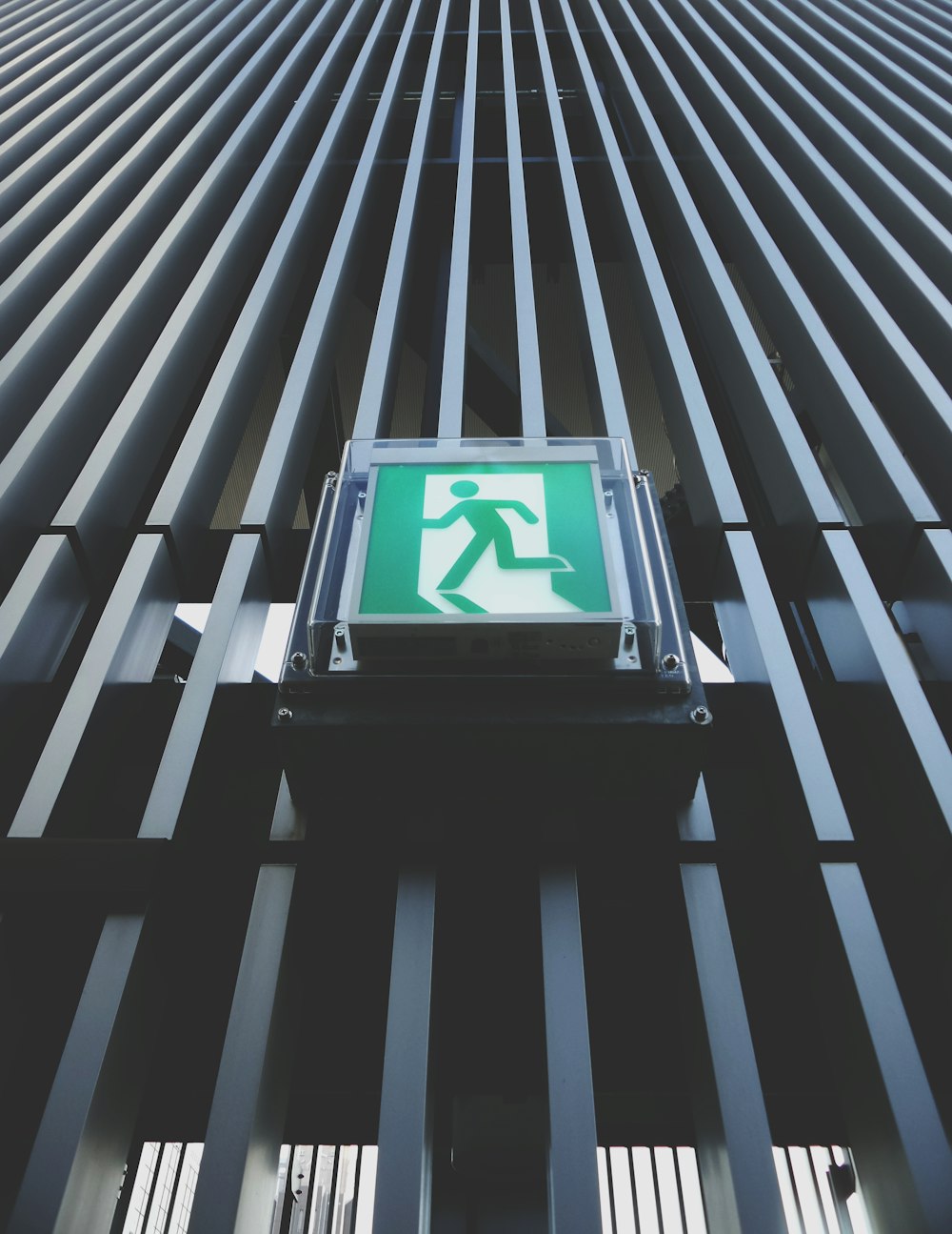 a green sign on the side of a tall building