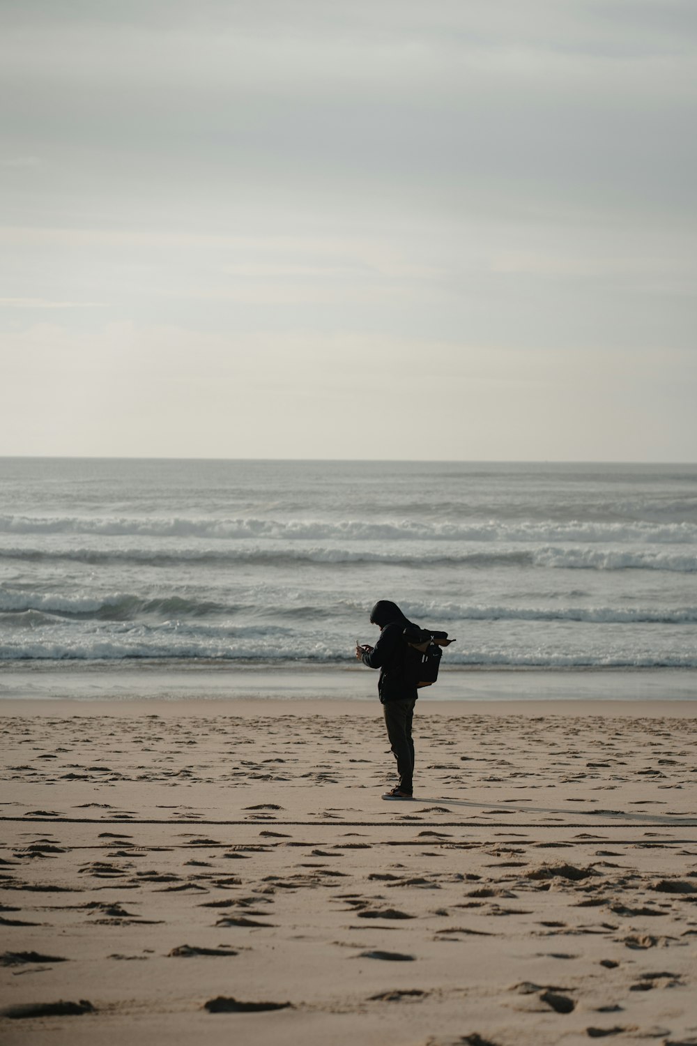 a person standing on top of a sandy beach