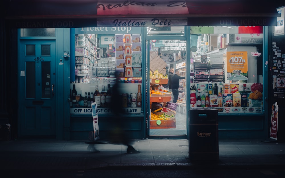 a person walking past a store front at night
