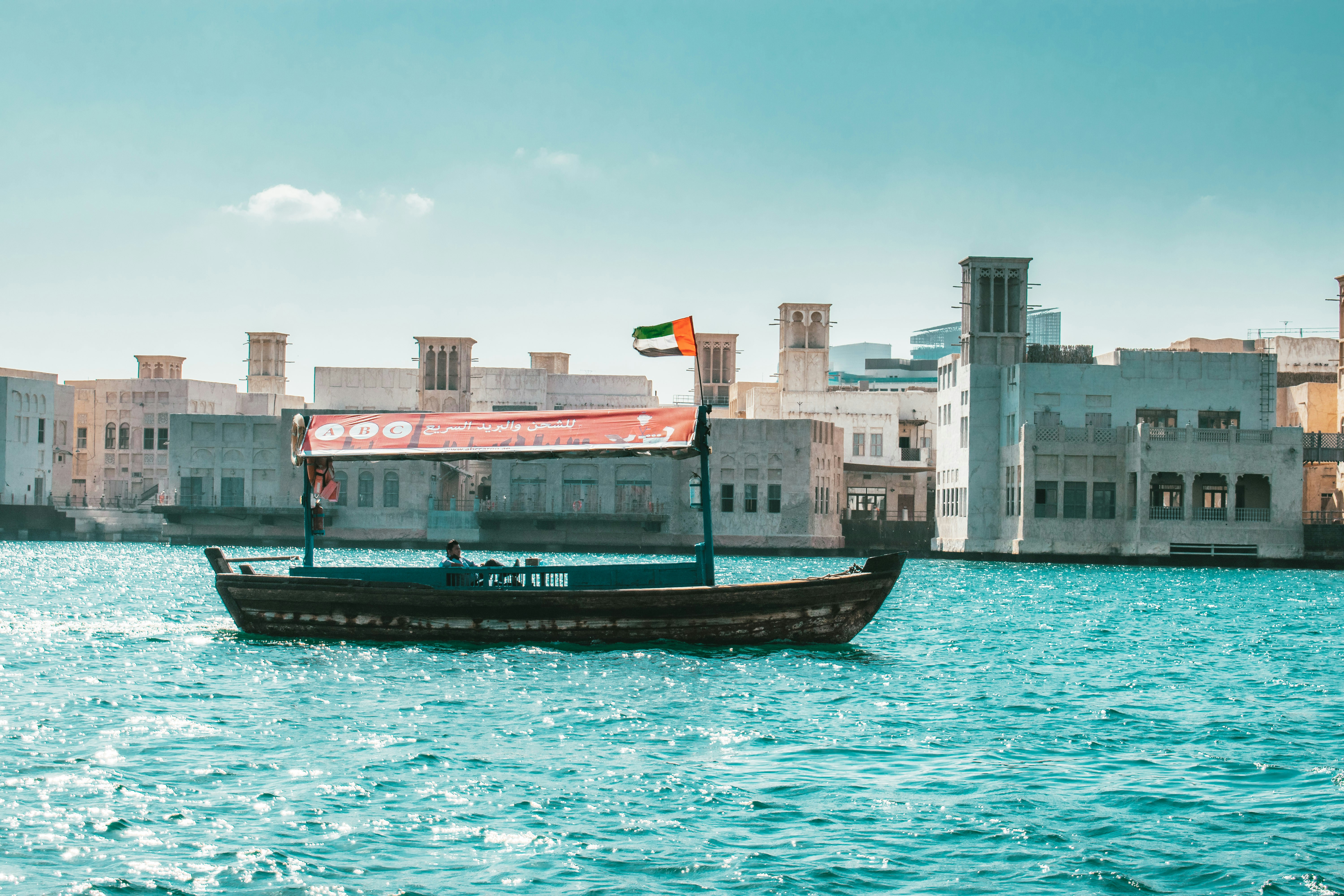 Traditional abra boats on Dubai Creek with historic buildings in background