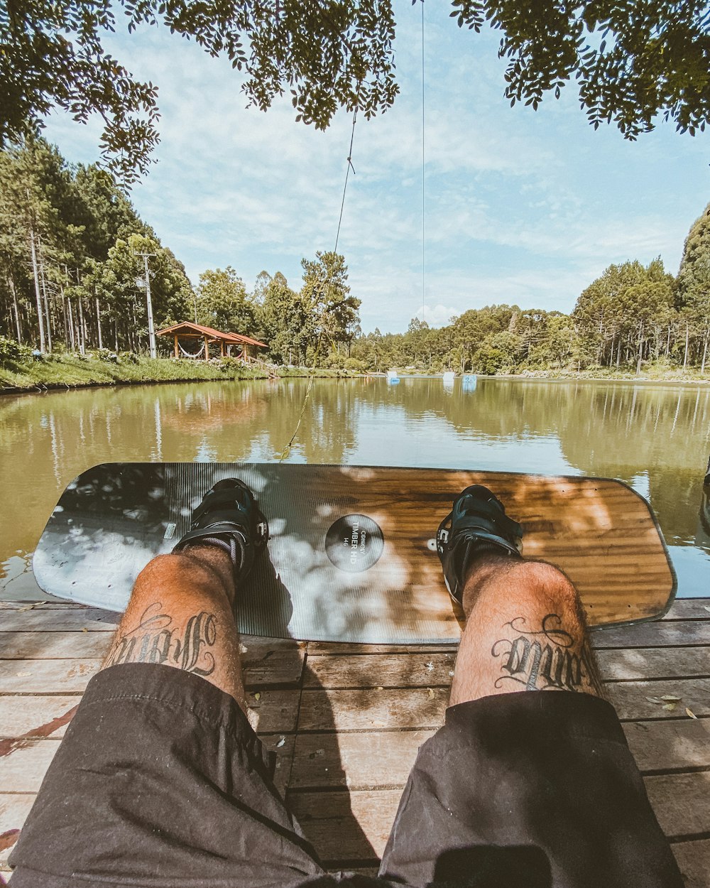 Una persona sentada en un banco junto a un lago